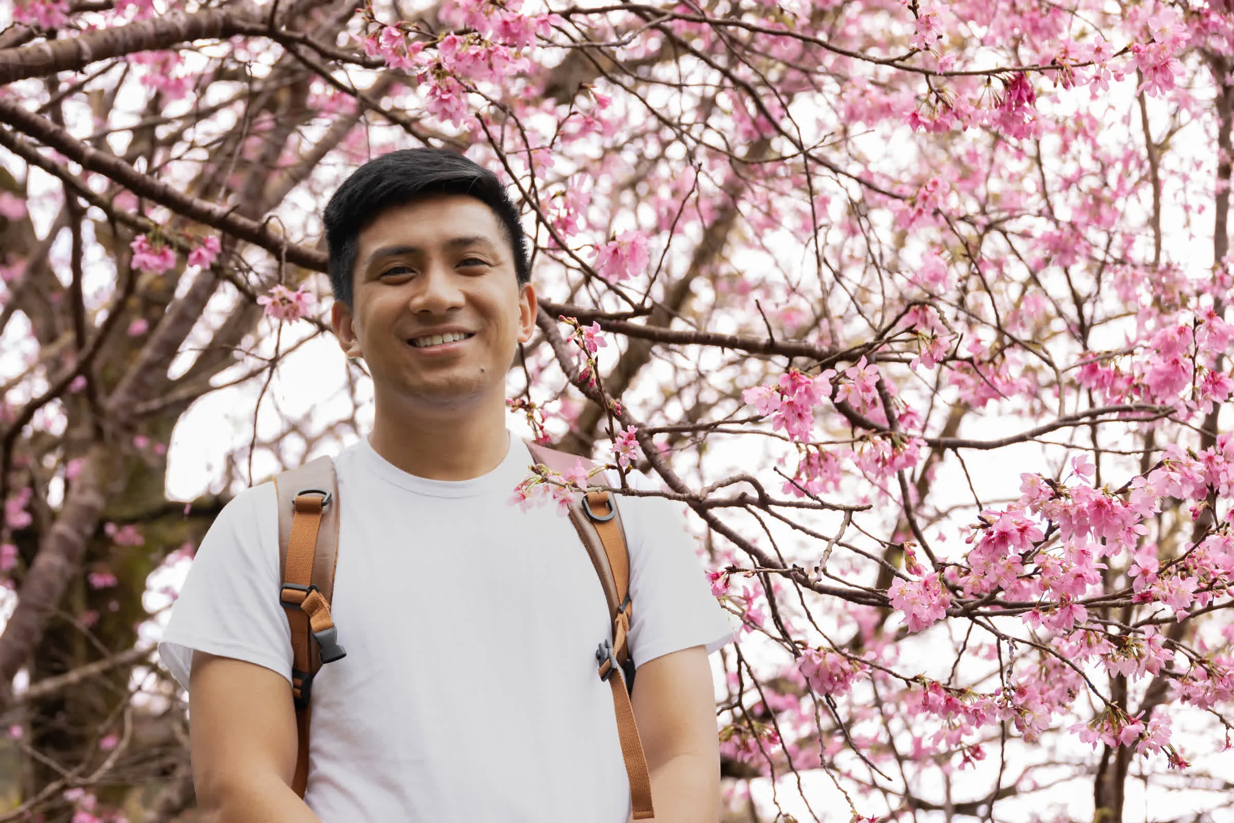 Eric in front of cherry blossoms.